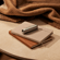 Ploom AURA front panels with Jet Black Augmented Pattern placed on top of a stack of notebooks.
