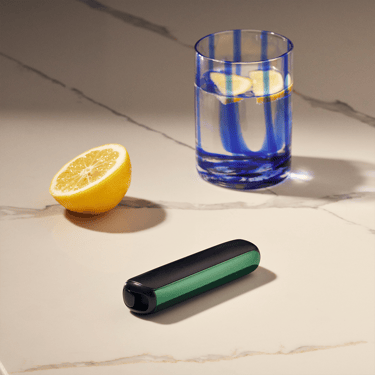 Ploom AURA front panel Amazon Green accessory attached to device on a table.