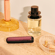 Ploom AURA front panel Dark Orchid accessory attached to device on a dressing table.
