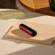 Ploom AURA front panel Lava Red accessory attached to device on a table.