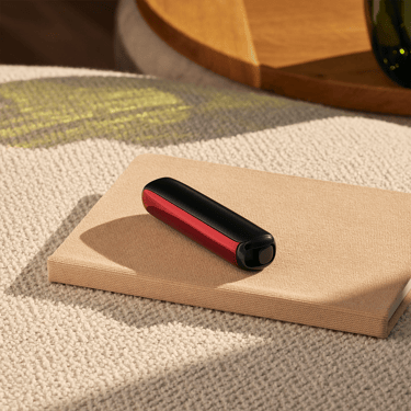 Ploom AURA front panel Lava Red accessory attached to device on a table.