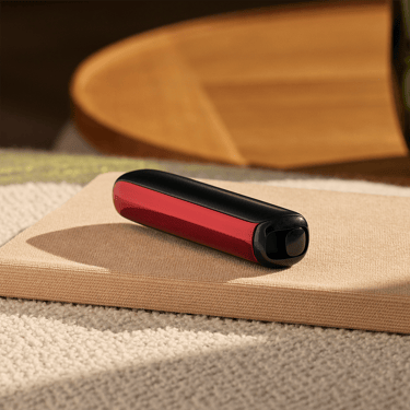 Ploom AURA front panel Lava Red accessory attached to device on a table.