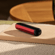 Ploom AURA front panel Lava Red accessory attached to device on a table.