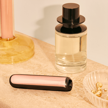 Ploom AURA front panels with Rose Gold Augmented Pattern placed on a dressing table.
