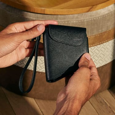 Hand holding a Ploom Duo Carry Case Jet Black accessory
