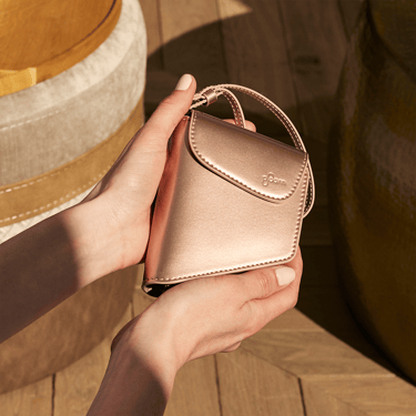 Hand holding a Ploom Duo Carry Case Rose Gold accessory
